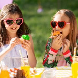 two girls with sunglasses and eating cupcakes