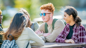 teens sitting at a table outside